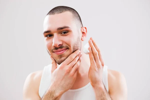 Jovem Está Aplicando Creme Barbear Seu Rosto — Fotografia de Stock
