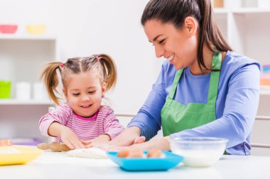 Mutlu anne ve kızı çerezleri onların mutfakta yapıyoruz. 