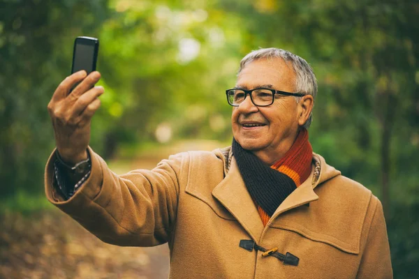 Счастливый Пожилой Мужчина Делает Селфи Парке Осенью — стоковое фото