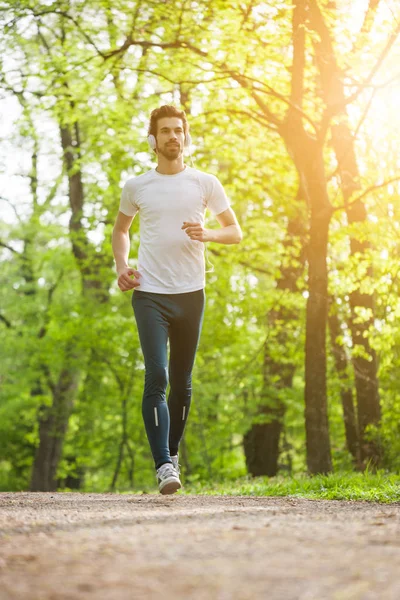 Joven Está Corriendo Parque Está Escuchando Música Los Auriculares —  Fotos de Stock