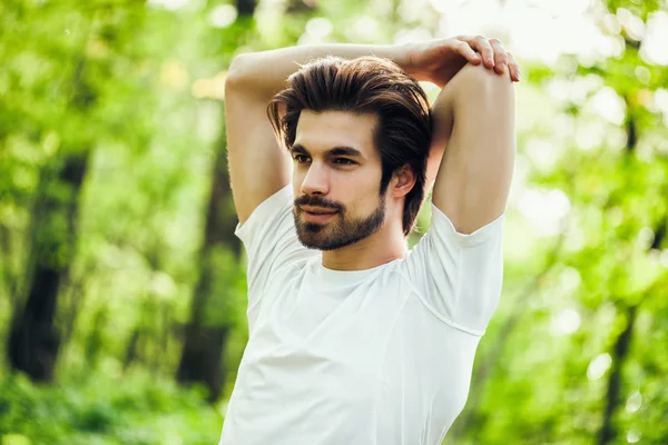 Genç adam egzersiz olduğunu. O vücudu germe. 