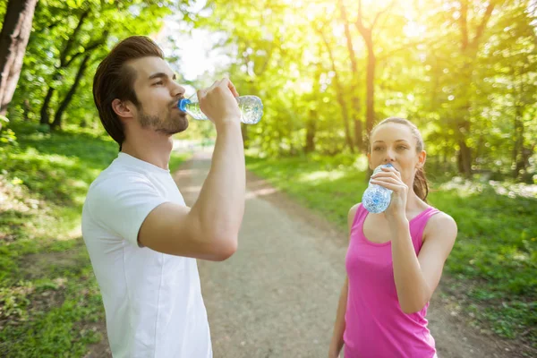 Pareja Joven Haciendo Ejercicio Parque Están Bebiendo Agua —  Fotos de Stock