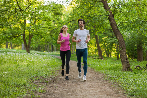 Young couple is jogging in park. 