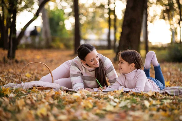 妈妈和女儿在公园里享受秋天 小女孩在画画 — 图库照片