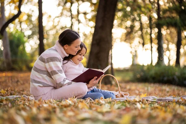 Мать Дочь Наслаждаются Осенью Парке Маленькая Девочка Учится Читать — стоковое фото