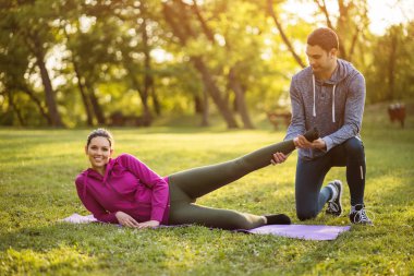 Fizyoterapist genç hastaya siyatik kurtarma için egzersizler gösteriyor.
