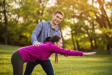 Fizyoterapist genç hastaya siyatik kurtarma için egzersizler gösteriyor.