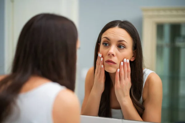 Müde Frau Blickt Badezimmer Auf Ihre Augenbeutel — Stockfoto