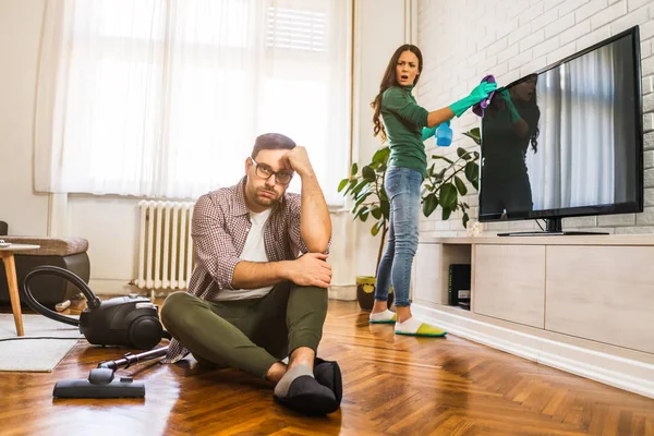 男人是懒惰的他的妻子告诉他继续打扫他们的公寓 — 图库照片