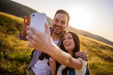 Mutlu çift dağda yürüyüş. Selfie çekiyorlar..