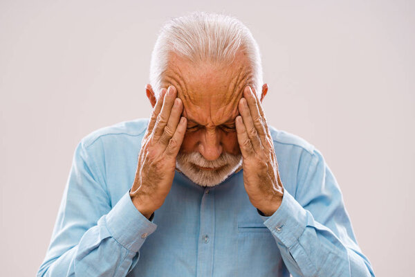 Portrait of senior man who is having headache.