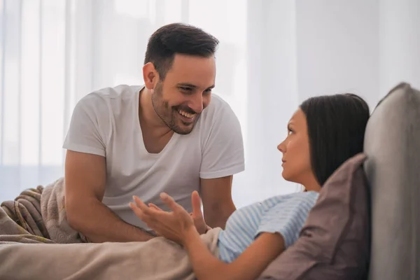 Young couple is taking in bed. Woman is offended and angry.