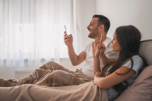 Junges Glückliches Paar Schaut Morgens Bett Aufs Smartphone — Stockfoto