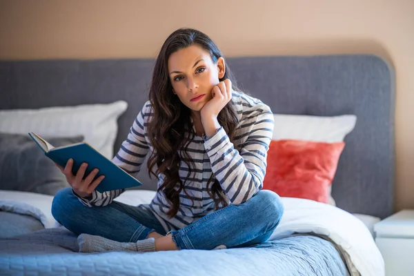 Γυναίκα Κάθεται Στο Κρεβάτι Στο Σπίτι Της Και Διαβάζει Βιβλία — Φωτογραφία Αρχείου
