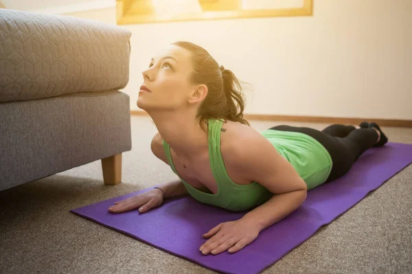 Ung Kvinna Utövar Yoga Hemma Bhujangasana Cobra Pose — Stockfoto