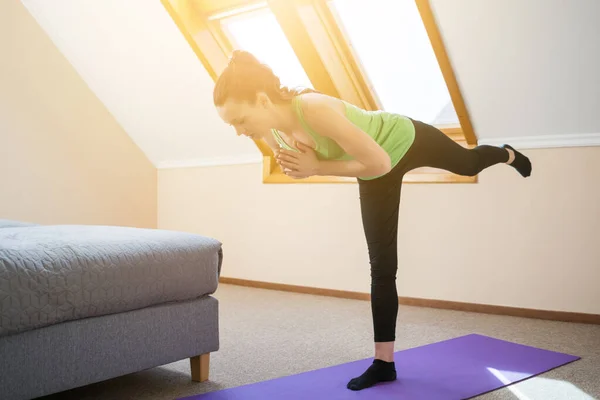 Ung Kvinna Utövar Yoga Hemma Krigarens Syfte Virabhadrasana — Stockfoto