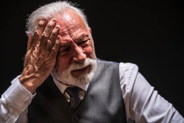 Siyah arka planda depresif yaşlı adamın portresi.