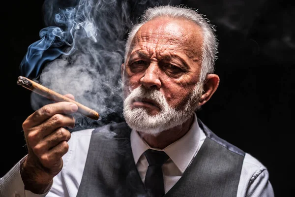 严肃的老年人吸烟雪茄的画像 — 图库照片