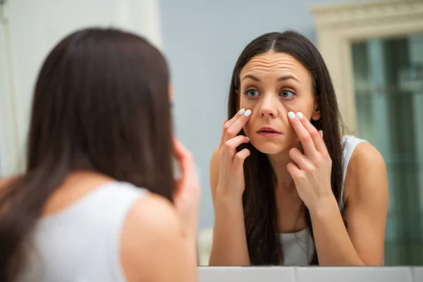 Müde Frau Blickt Badezimmer Auf Ihre Augenbeutel — Stockfoto