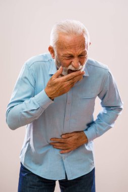 Portrait of senior man who is having pain in stomach. clipart