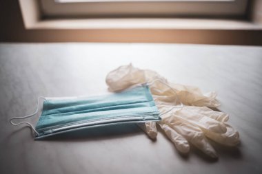 Tıbbi maske ve eldiven görüntülerini kapatın. Virüs salgını koruma kavramı.