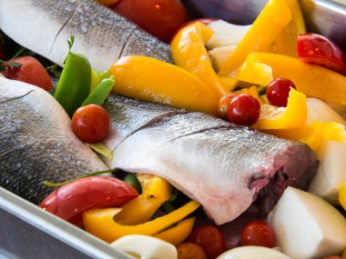 Levrek, dolmalık biber, domates ve soğan pişirmeye hazır.