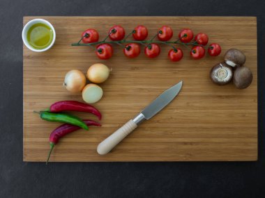 Taze sebze, zeytinyağı ve ahşap zemin üzerinde bıçak.