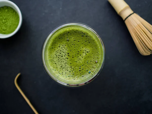 Fincanda kibrit yeşil çay ve arka planda bambu perdesi.