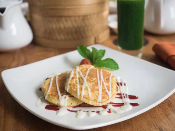 Tahta masada yeşil meyve suyu ile kahvaltı krepleri.