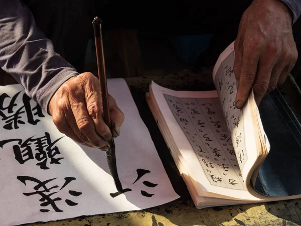 A calligrapher hand writing chinese calligraphy