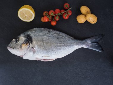 Çipura, limon, domates ve patates. en üstteki görünüm