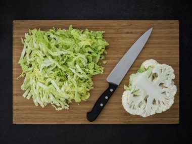lahana, karnabahar ve tahta kesme üzerinde mutfak bıçağı. en üstteki görünüm