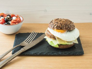 vejetaryen çizburger ve domates, zeytin ve beyaz salata.