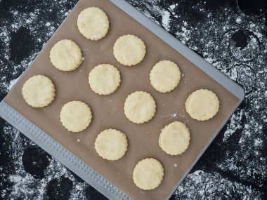 Fırın tepsisinde el yapımı çiğ çörekler hazır. en üstteki görünüm