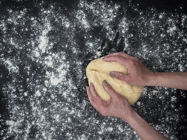 Kadının elleri çörek hamuru yoğuruyor. en üstteki görünüm