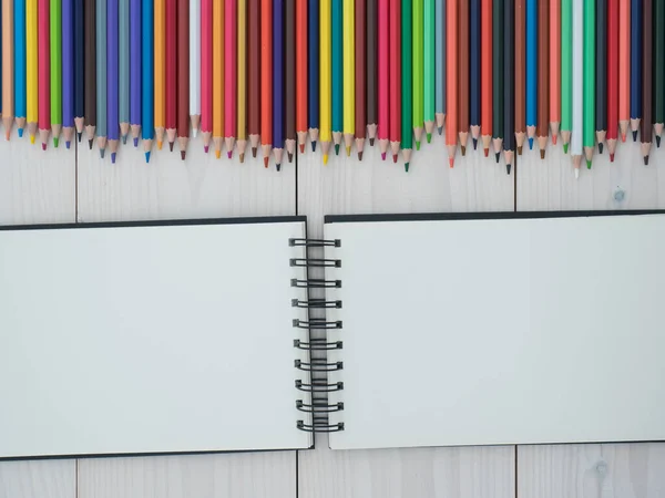 Conjunto Lápices Colores Dispuestos Una Fila Cuaderno Sobre Fondo Madera — Foto de Stock