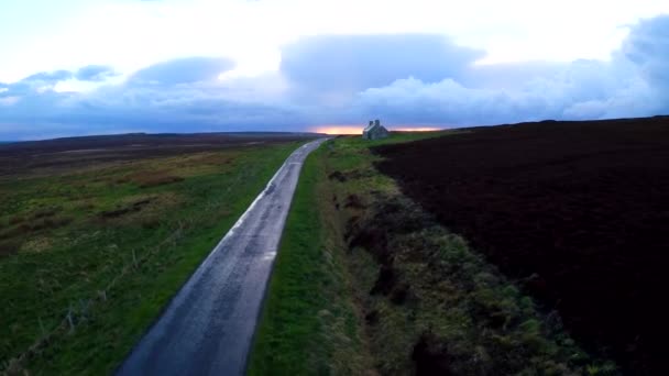 遠く放棄された石造りの建物と雨の後 スコットランドやアイルランドを介して美しい道路上の空中 — ストック動画