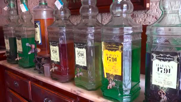 キューバのハバナの古い街にある店の屋台には 昔ながらのオイルと香水のボトルが並んでいます — ストック動画