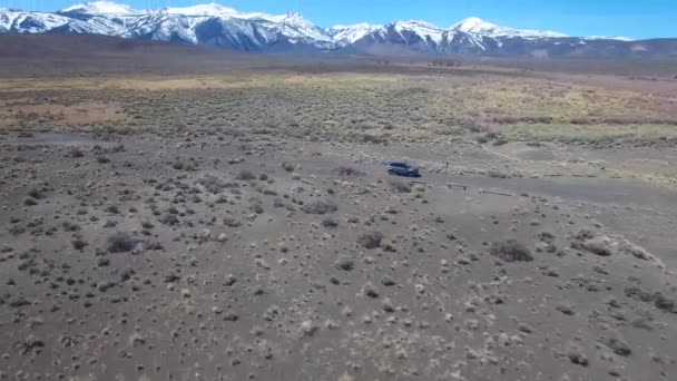シエラネバダ山脈とモハベ砂漠の未舗装道路を走行する4Wdの上の空中 — ストック動画