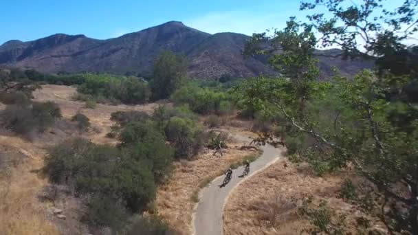 カリフォルニアの山に乗っている2人のマウンテンバイクに続く良い航空機 — ストック動画