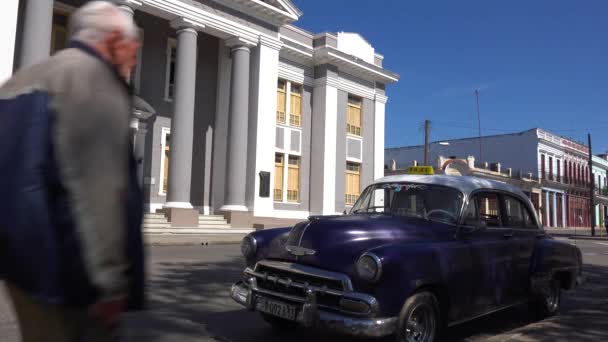 在古巴西恩富戈斯的中央广场上矗立着一座宏伟宏伟的建筑 有着经典的旧车前景 — 图库视频影像