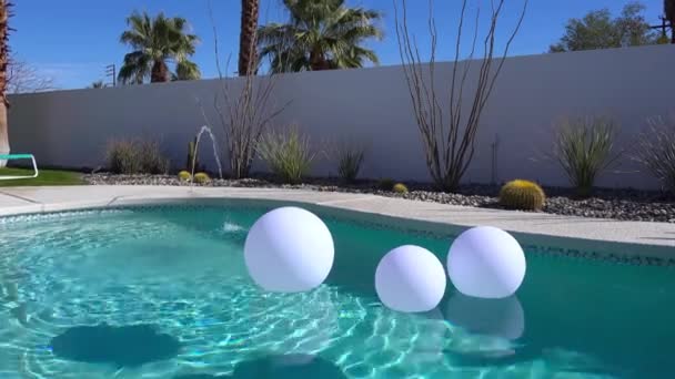 在棕榈泉的家 人造充气球漂浮在游泳池里 — 图库视频影像