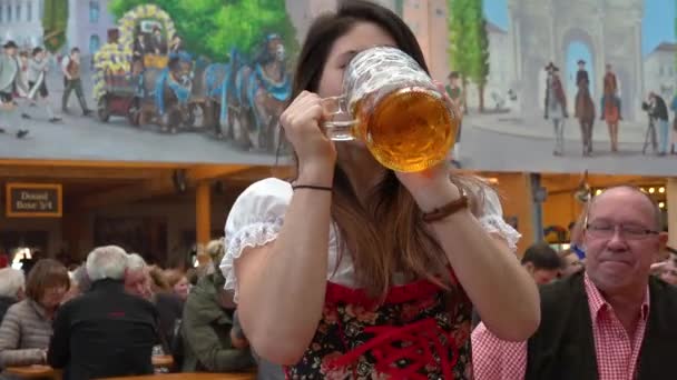 德国Oktoberfest 一个漂亮女孩喝了一大杯啤酒 — 图库视频影像