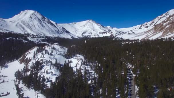 Uma Antena Sobre Uma Estrada Remota Através Das Montanhas Nevadas — Vídeo de Stock