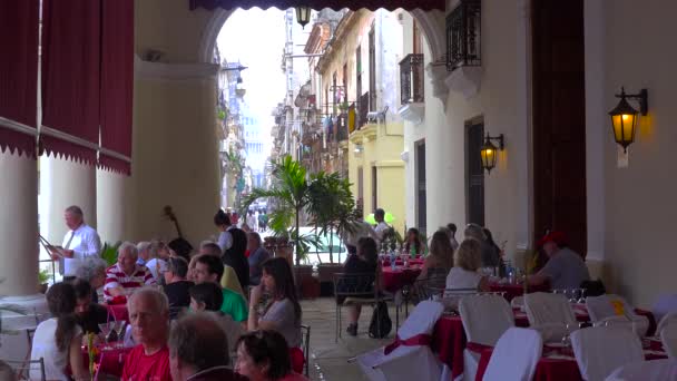 在古巴哈瓦那老城的一条狭窄街道旁边 成群的人在一家餐馆里吃饭 — 图库视频影像