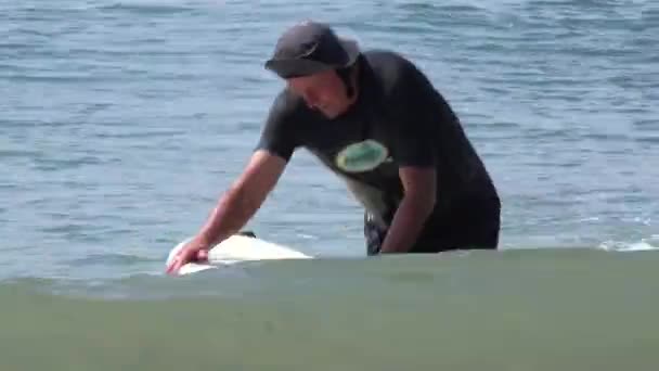 一个中年冲浪男在波浪中划桨 然后离开了水面 — 图库视频影像