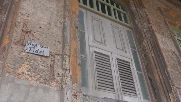古巴哈瓦那一座建筑的陈旧不堪的窗户上挂着一个标牌 上面写着Viva Fidel — 图库视频影像
