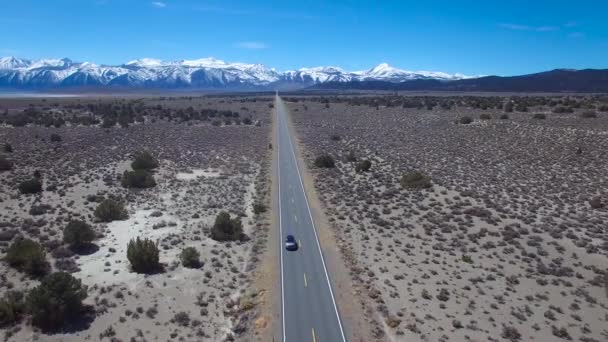 シエラネバダ山脈とモハベ砂漠の舗装道路を走行する4Wdの上の空中 — ストック動画
