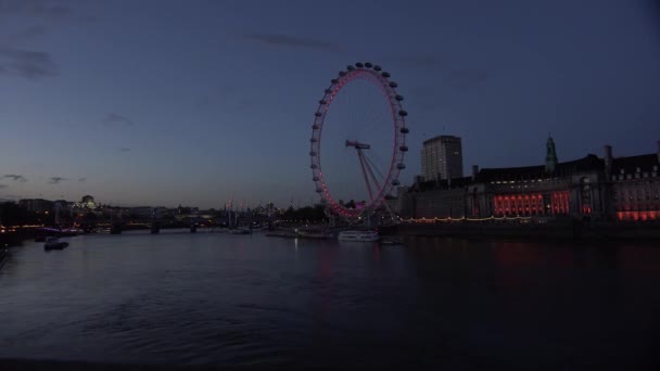 英国泰晤士河沿岸的船只夜间经过伦敦眼 — 图库视频影像