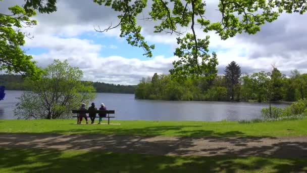 在Loch Lomand Scotland 人们坐在长椅上欣赏风景 — 图库视频影像